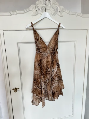 Klänning - Mönstrad klänning med band i midjan som man kan knyta både fram och bak, går ner till mitten av låret. Jag är 170cm 🫶🏼🌼