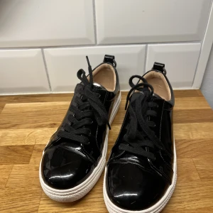 Sneakers i lack  - Svarta sneakers i lack från Even and Odd. Sparsamt använda, dock litet slitage i hälen och på framsidan som på bilden. Storlek 37. Perfekta vardagsskor till sommaren men jag använder sällan sneakers. 