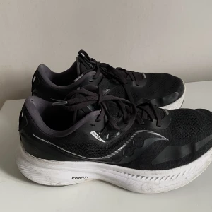 Saucony träningssko - Svarta saucony skor som funkar till träning eller på jobbet, säljer pga vuxit ur dom tyvärr  Kan upplevas lila på bild på vissa ställe men färgen är grå men fångas inte upp på kameran  Nypris 1699kr
