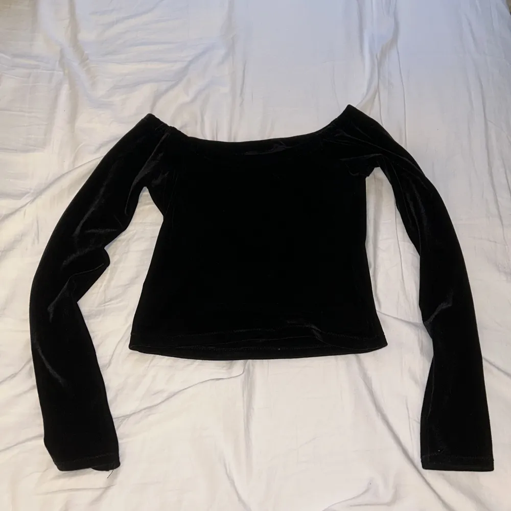 Säljer den här svarta offshoulder tröjan i sammet som jag inte vet vart den är ifrån, skulle tro att den är XS då den är för liten för mig, knappt använd. Toppar.