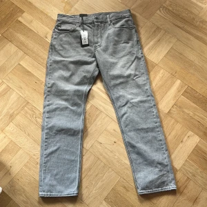 Grå G star jeans oanvända  - Snygga gråa Gstar jeans perfekta inför sommaren! Byxorna är helt oanvända och köptes för 1449kr . Modellen heter Gstar TRIPLE A REGULAR STRAIGHT JEANS