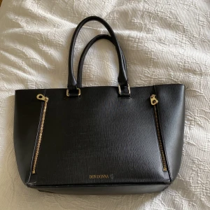 Don Donna väska  - Säljer min använda Don Donna väska. Den är svart med guldiga detaljer. Det har några defekter därav priset!💕