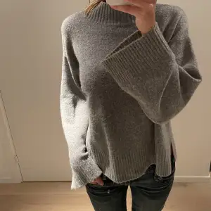 Grå stickad tröja från Pull & Bear. Otroligt mjuk i material och är i super bra skick. Ärmen blir vidare desto längre ner den faller och så finns det en slitt på båda sidorna av tröjan (se bild 3). Skriv om du har några frågor☺️