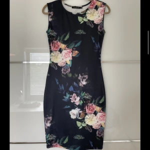 Blommig klänning - Klänning köpt utomlands, strl S/M (stretchig). Elegant och figurnära. 