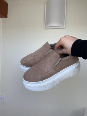 Sneakers från nelly  - Beiga sneakers från Nelly. Supersnygga, jättesköna och passar perflet nu till våren. Använt dem ca 5 gånger. Lite smutsiga på sulan, men det syns knappt. 