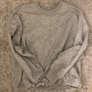Grå sweatshirt  - En vanlig grå sweatshirt, osäker var den är ifrån  