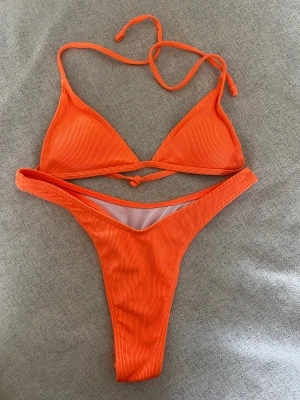 Neon bikiniset - Organge neon bikini från Shein. Använd fåtal gånger. Fint skick, lappr är avklippna. Fodrade kupor på överdelen.