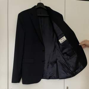 Kavaj från Acne Studios, i princip helt ny/använd en gång. Väldigt mörkblå färg, nästintill svart. Köpt i butik för närmare 4000kr, säljer nu för 1500kr.   Fin till studenten eller som julklapp. 