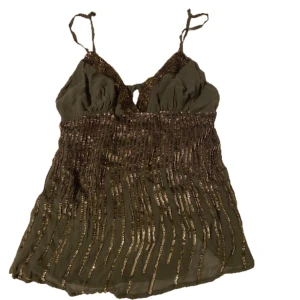 Grön Top med Paljetter - Super söt topp med paljetter. Med toppen medföljs en matchande kjol, om bilden kjolen inte är med i annonsen så be mig om bild💕 Vet inte vilken storlek det är men jag skulle säga att den ligger på S-M. 