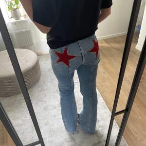 Jeans med blå tvätt och röda stjärnor baktill. I storlek 24. I bra skick men lite väl små för mig. 