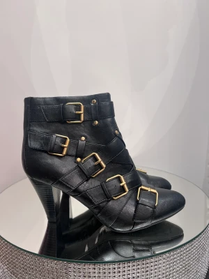 Boots  - Snygga boots med metallspännen. På sista bilden kan man se lite defkt 