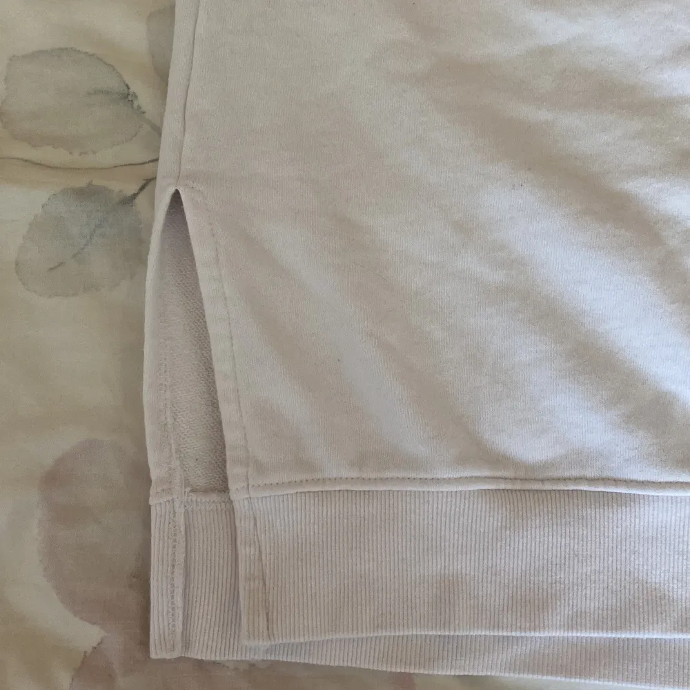 Detta är ett vitt oversized t-shirt. Materialet är väldigt tjockt, det har även två öppningar längst ner på tröjan. Just nu har den en fläck men det tar jag hand om!. T-shirts.