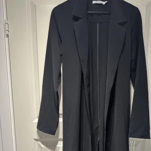 Trenchcoat  - Svart trenchcoat med skärp till. 