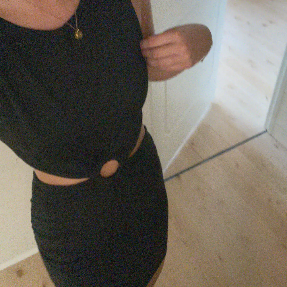Snygg svart klänning som är delad fast sitter ihop med en rund knytning kan man säga💞. Klänningar.