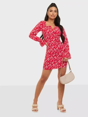 Blommig Mini Klänning  - Röd/Vit blommig mini kläning från Nelly. Endast testad, aldrig använd. Säljer då den är för liten för mig. Storlek 36. Orginal pris: 330kr
