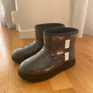 Gummi uggs - Jätte sköna uggs som passar perfekt till en regnig höstdag.  Det är en vattentät modell i genomskinlig plast med teddyfoder som delvis är i ull. Skafthöjd ca 13 cm Skorna är i ett mycket bra skick eftersom jag inte använt de så mycket. Ordpris: 1500kr