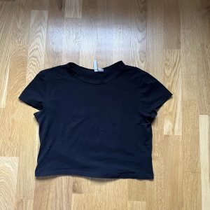 topp - Kort svart topp, skönt material, kort, slutar precis över naveln. Ej tajt! 