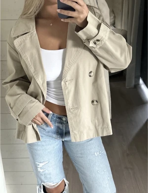 Trenchcoat  - Supersnygg beige kort trenchcoat från Monki i storlek S🩷 Endast använd fåtal gånger! (Lånade bilder, men det är min jacka som är med på bilden)