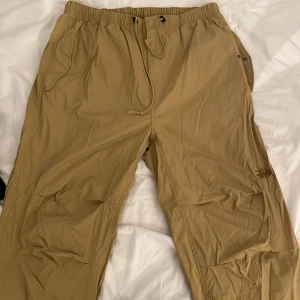 Stussy/stüssy - byxor - Hej! Jag säljer mina stussy byxor som jag köpte på Paul and Friends för 900kr men nypris ligger på 2000kr, säljer de för jag inte vill ha de längre (litet hål vid snören där nere)