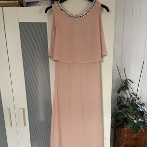 Underbar balklänning - Säljer min underbara balklänning då den tyvärr aldrig kommer till användning. Köpt på Nelly för flera år sedan. Använd ett fåtal gånger. Nyskick. Fotlång på mig som är 176 cm.