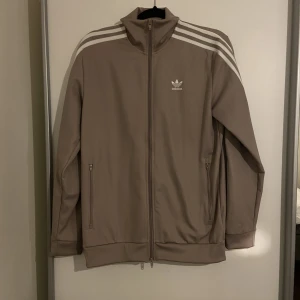 ADIDAS TRÖJA  - Kofta/tröja begie tröja från adidas, använd 1 gång, men i topp skick, storlek S, köpte för 1000kr, pris går att diskutera. Säljer även byxan till - men i annan annons