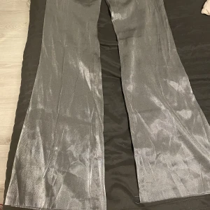 Silvrig sett  - Säljer det här fina settet för 400kr tillsammans. Byxorna har storlek 40 och kavajen har storlek 36. Helt oanvända. Original priset för byxorna är 599kr och kavajen 499. Frakt ingår ej. 