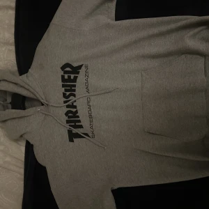 En grå trasher hoodie - En snygg trasher hoodie i strl M, bra skick. Nypris 1250kr 