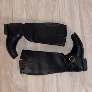 Primeboots  - Stövlar från primeboots med gulddetaljer och kedja baktill.