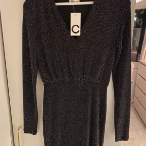 nyårsaklänning - Aldrig använd, nyårsklänning från cubus sitter taja nertill och pösigt upptill, superfin, ny pris 299 säljer för 100