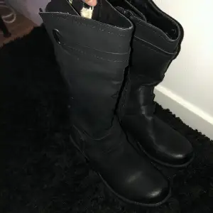 Dessa svarta boots med brun klack har endast används 1-2 gånger och är i fint skick! Insidan av skon är klätt i teddyfoder.