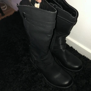 Svarta boots/Svarta stövlar i fint skick  - Dessa svarta boots med brun klack har endast används 1-2 gånger och är i fint skick! Insidan av skon är klätt i teddyfoder.