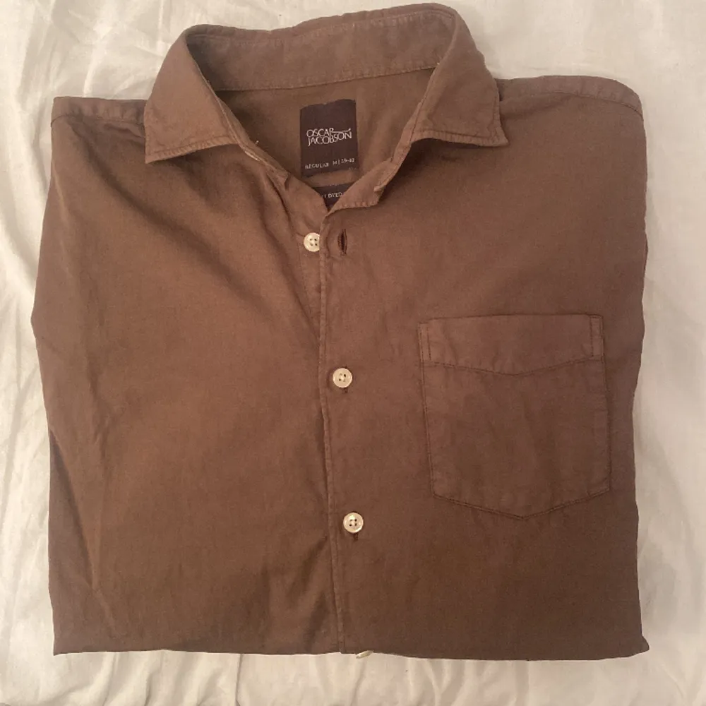 Brun skjorta från Oscar Jacobson som endast har använts 3 gånger. Nypris: 1200kr. Skjortor.