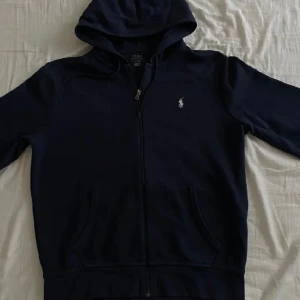 Ralph Lauren Zip Hoodie - Hej. Säljer denna as snygga Ralph lauren hoodie i size S. Skick är 8/10. Sparsamt använd. Köpt för 2000kr. Hör av dig för mer frågor!