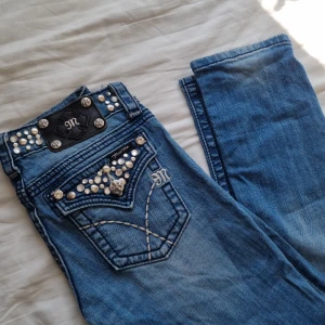 Miss Me jeans glitter - Superfina lågmidjade jeans från Miss Me! Modellen heter skinny, men jag skulle säga att dom är lite raka. Bra skick med fina detaljer. Strl 26.  Midja rakt över 38 cm. Innerben 80 cm. Ytter 98 cm.