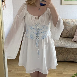 Vit klänning - Jättefin oanvänd klänning. Funkar bra för studenten. Kan vara aningen kort. Jag är 167cm för referens. Korsetten går inte att spänna åt utan är endast dekorativ.