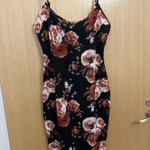 Klänning  - Blommig klänning, sitter tajt och bekvämt, man får fina former i den 