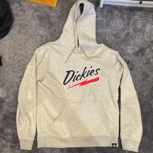 Dickies hoodie - Grå dickies hoodie med svart/rött tryck på framsidan. Storlek M och normal passform. Väldigt bra skick.