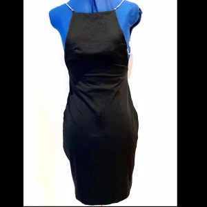 NY oanvänd klänning med strass-axelband  - NY oanvänd klänning med öppen rygg och strass-axelband  Storlek - S  Färg- svart klänning & silver strass   Djur och rökfritt hem