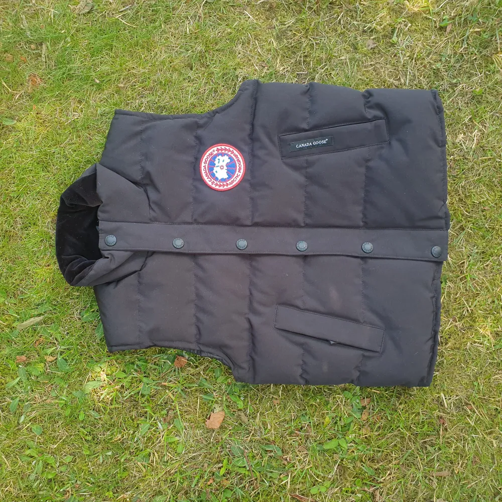 Canada goose väst i nyskick storlek 7-8 år använd varsamt vid väldigt få tillfällen. Storlek 7-8 år.  Västen är tjock och varm, perfekt nu inför Hösten.  Den kostade flera tusen ny men sonen har inte velat använda den!  Bilden är inte rättvis ej fläckar.. Övrigt.