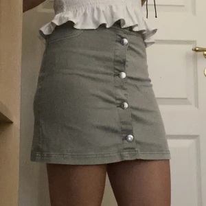 Jeanskjol - Denna jeanskjol har inga tecken på användning och säljer för att den inte används/är för liten.  Där kjolen sitter som högst är det ungefär 66cm i omkrets. Över midjan är det ca 80-85cm.  Tyget är i tunt jeanstyg i en mintgröna färg. 