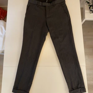Riktigt snygga kostymbyxor - Mörkgråa kostymbyxor från H&M i storlek 46. Passformen är slimfit och följer därför kroppen mycket snyggt.