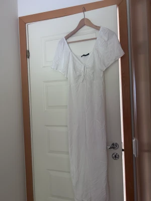 Vit långklänning  - Vit långklänning från lager 157, endast testad! Så fin och har knytning mellan brösten så man själv kan välja hur v ringad man vill ha den! 