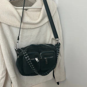 Noella väska  - Sparsamt använd så jätte fint skick. Rymmer mycket och två band att välja mellan, antingen det långa eller det med nitar (det långa går att ta av) TRYCK INTE PÅ KÖP NU