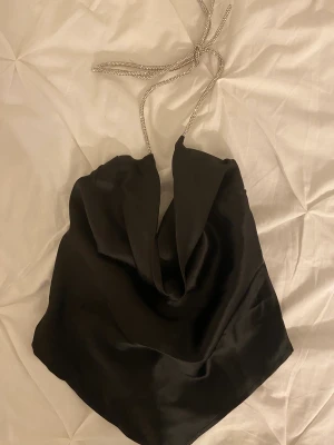 Svart topp - En svart topp med knytning i ryggen och glittriga band runt nacken 🩵 Jättefin och perfekt till nyår, aldrig använd 💙