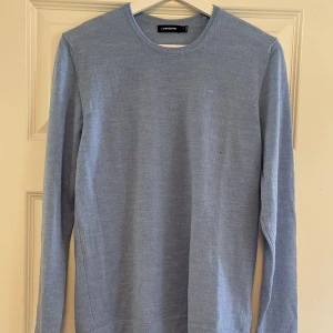 J.Lindeberg tröja  - Säljer nu min merino stickade tröja från J.Lindeberg. Bra skick 9/10. Men det finns ett litet hål under märket men det går att sy. Därav det låga priset. Nypris 1500kr.