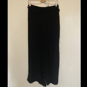 Svarta byxor - Svarta raka tygbyxor i mjukt, ledigt material som hänger fint. Midjebälte i samma material