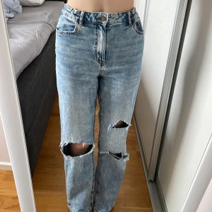 Jeans med hål - Jeansen är jögmidjade och vida i benen. Hålen är klippta på egen hand. De är använda men i väldigt bra skick. De är egentligen i storlek 158 men passar fortfarande mig som är 165. Justerbar i midjan. Säls på grund av att jag inte använder de längre⚡️