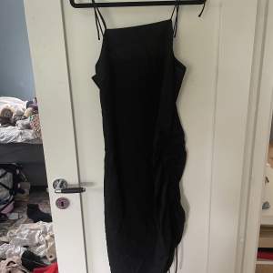 Snygg svart klänning från HM, med svarta rysch detaljer på sidan. Storlek 38 