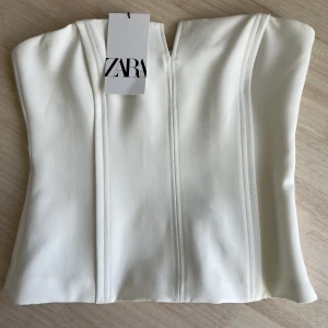 Vit topp - Vit topp som sitter så snyggt och ger en fin silhuett! Lite ”korsett”-liknande då materialet är rätt styvt! Från Zara, aldrig använd - prislapp kvar 💕