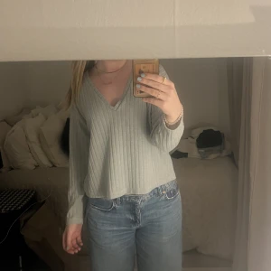 Ribbad långärmad tröja  - Långärmad v-ringad tröja med ribbat tyg. Skulle säga att färgen ligger mellan grön o blå. Använd få gånger. Skriv för mer info/bilder!!